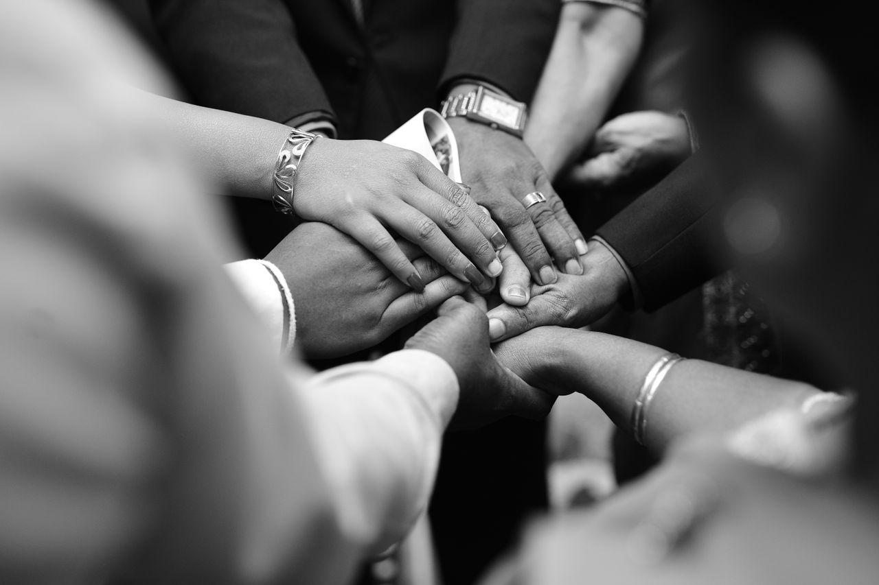 portfolio-04 A close-up black and white photo of diverse hands united in prayer, symbolizing spiritual unity.