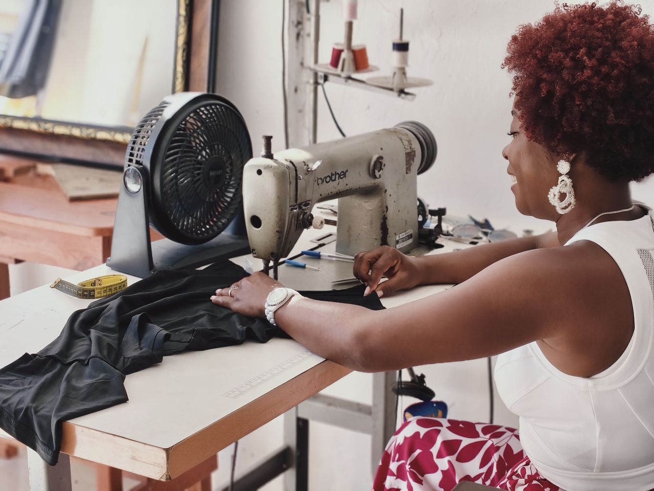 A dedicated seamstress working on fabric using a vintage sewing machine in a craft room.